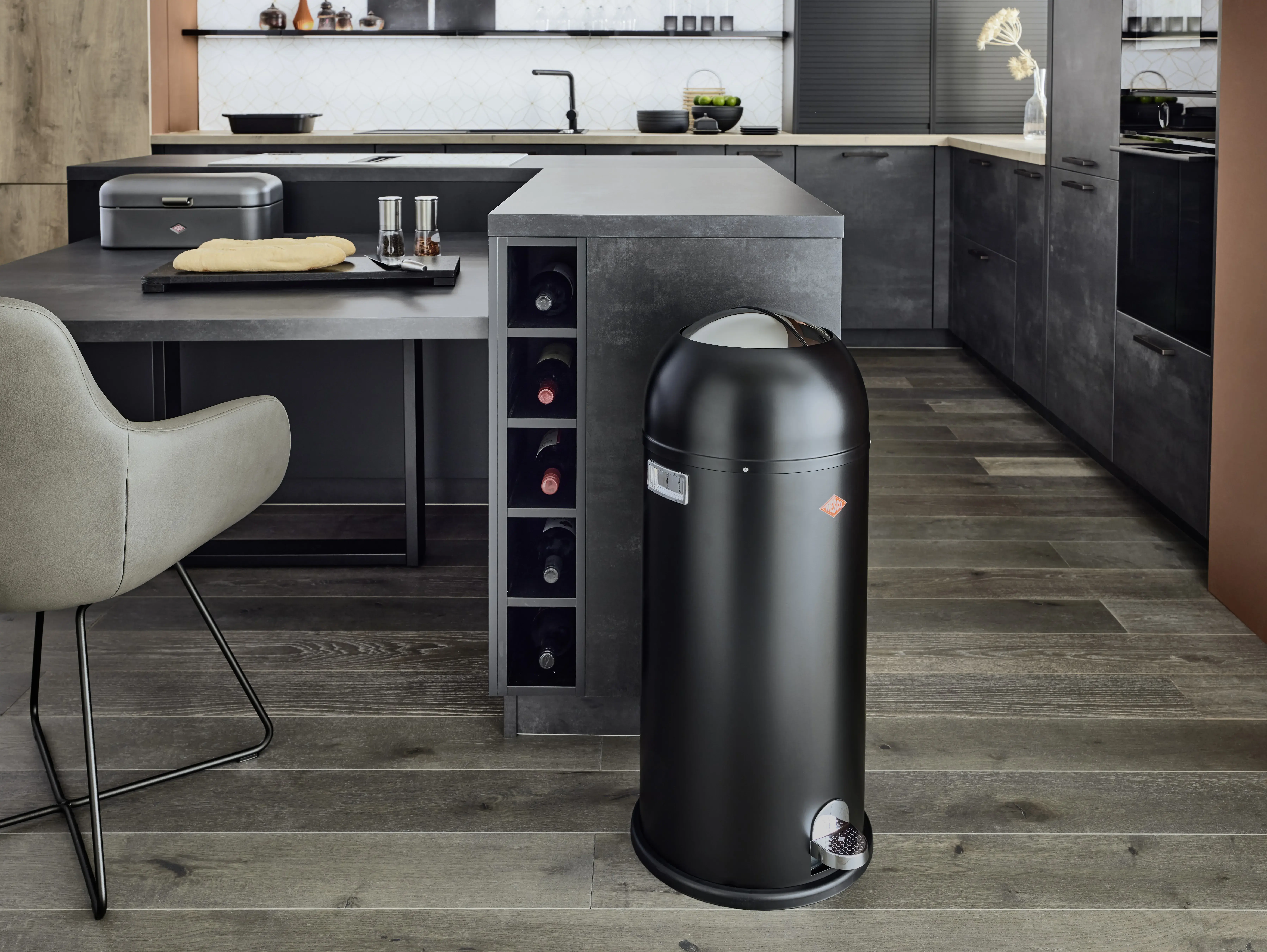 Moderne Küche mit schwarzem Mülleimer auf Holzboden, graue Möbel und Arbeitsplatte, Siemens Geräte, Wesco Mülleimer